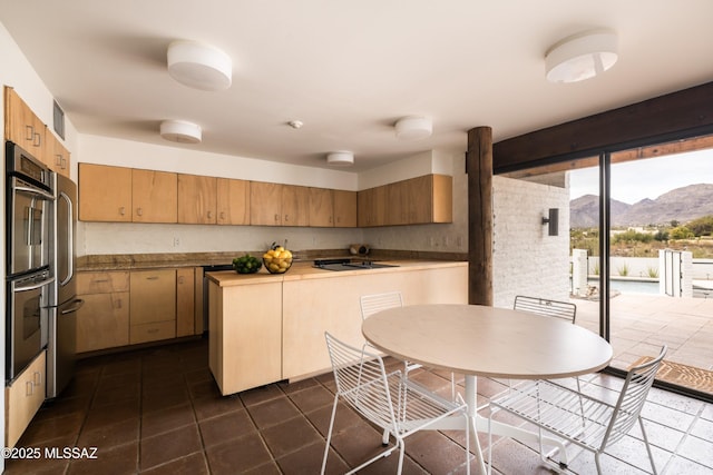 kitchen with dark tile patterned floors, visible vents, a mountain view, and stainless steel appliances