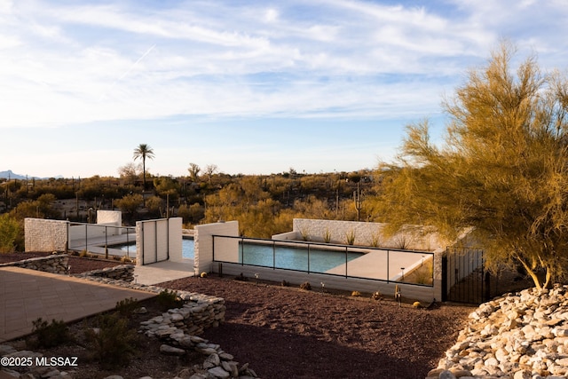 view of swimming pool featuring a gate and fence