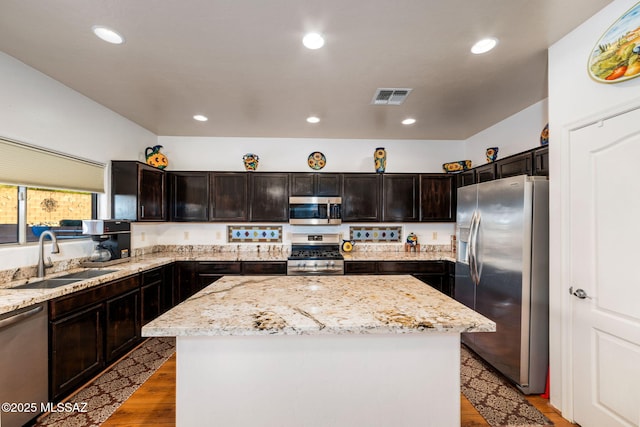 kitchen featuring light wood-type flooring, visible vents, a center island, a sink, and stainless steel appliances