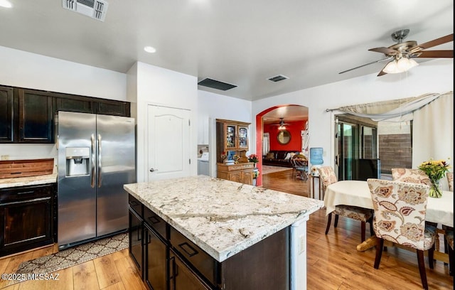 13978 N Big Wash Overlook Pl, Tucson, AZ 85739 - kitchen with stainless steel fridge with ice dispenser, a ceiling fan, arched walkways, light wood-type flooring, and light stone countertops