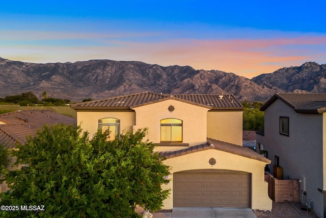 13978 N Big Wash Overlook Pl, Tucson, AZ 85739 - mediterranean / spanish home with a mountain view, a tile roof, driveway, stucco siding, and an attached garage