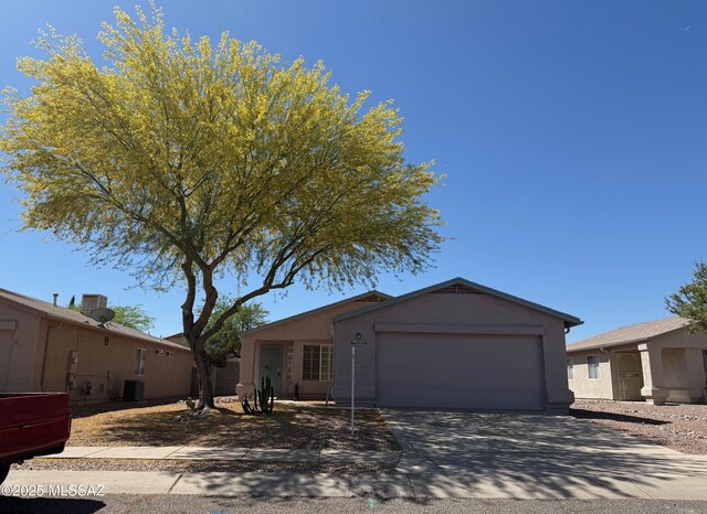 ranch-style home featuring stucco siding, an attached garage, and concrete driveway