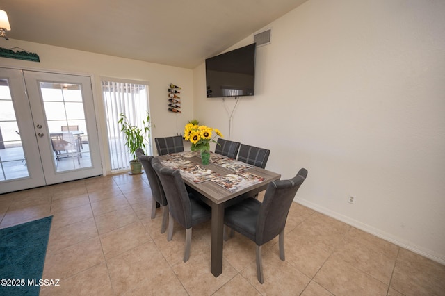 dining area with visible vents, baseboards, lofted ceiling, light tile patterned flooring, and french doors