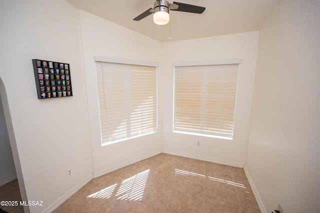 unfurnished room featuring tile patterned floors, baseboards, and ceiling fan