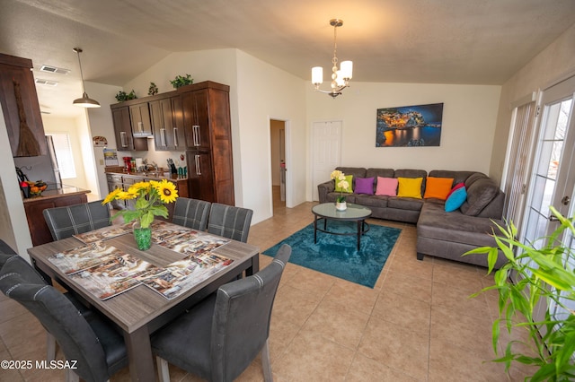 dining room with visible vents, lofted ceiling, an inviting chandelier, and light tile patterned flooring