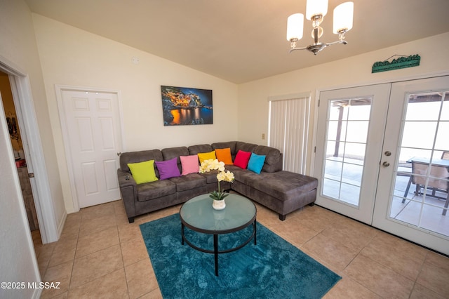 living area with light tile patterned floors, a notable chandelier, french doors, and vaulted ceiling