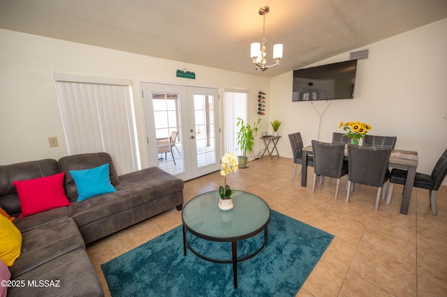 tiled living area with french doors, lofted ceiling, an inviting chandelier, and visible vents