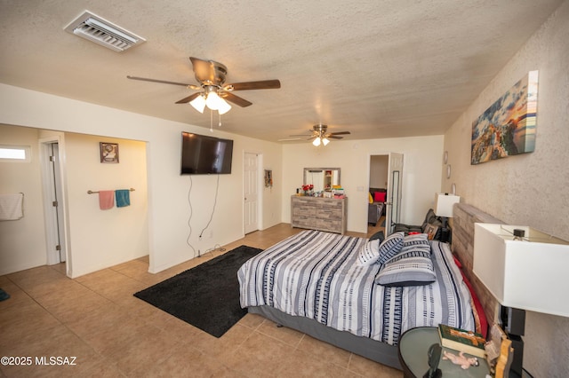 bedroom featuring light tile patterned flooring, a ceiling fan, visible vents, and a textured ceiling
