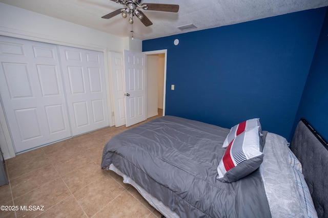 bedroom featuring tile patterned floors, visible vents, a closet, and ceiling fan