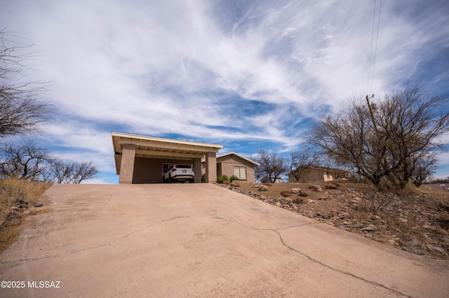 exterior space featuring stucco siding, an attached carport, and driveway