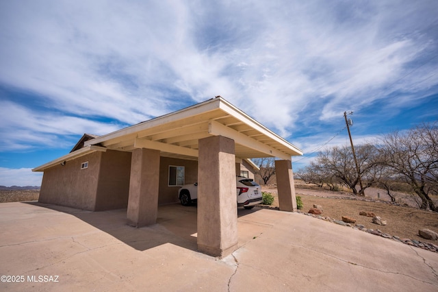 view of patio / terrace with an attached carport and driveway