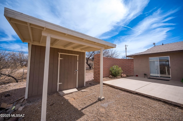 exterior space featuring a storage unit, an outbuilding, and fence