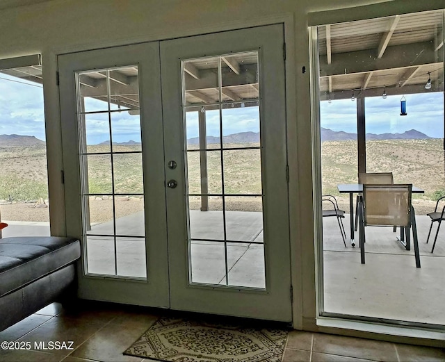 doorway to outside with a wealth of natural light, a mountain view, and french doors