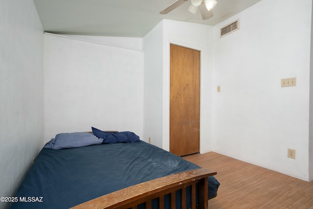 bedroom featuring light wood-style floors, visible vents, and ceiling fan