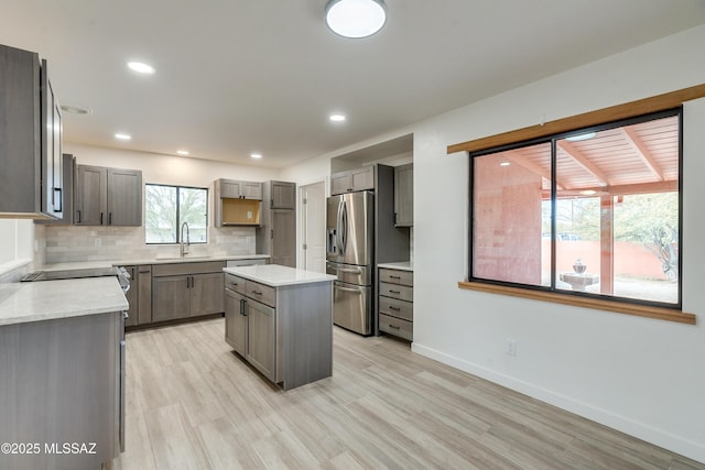 3053 W Lobo Rd, Tucson, AZ 85742 - kitchen with a sink, stainless steel fridge, light wood finished floors, decorative backsplash, and baseboards