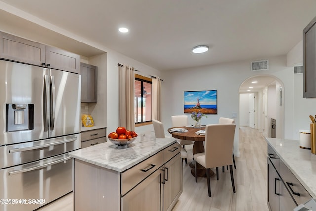 3053 W Lobo Rd, Tucson, AZ 85742 - kitchen featuring visible vents, arched walkways, stainless steel fridge with ice dispenser, and light stone countertops