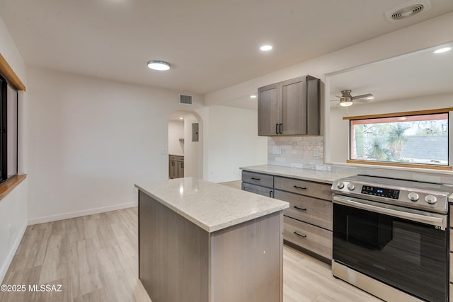 3053 W Lobo Rd, Tucson, AZ 85742 - kitchen featuring electric stove, arched walkways, visible vents, and backsplash