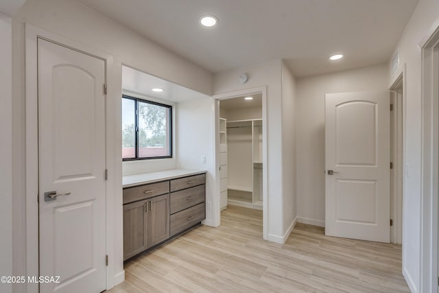3053 W Lobo Rd, Tucson, AZ 85742 - bathroom with a walk in closet, wood finished floors, recessed lighting, baseboards, and vanity