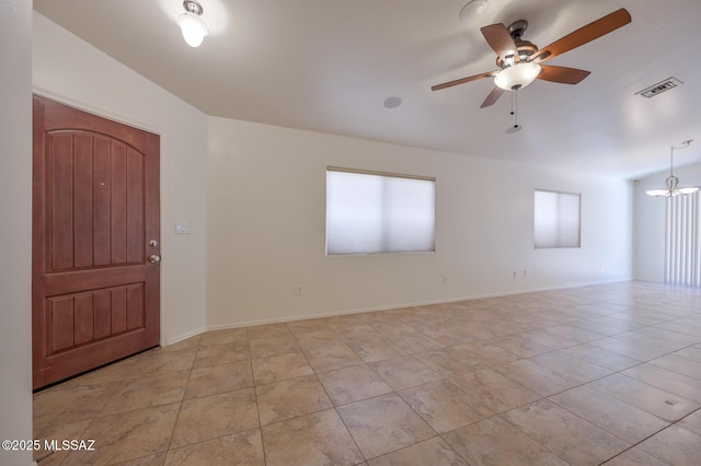 spare room with light tile patterned floors, visible vents, ceiling fan with notable chandelier, and baseboards