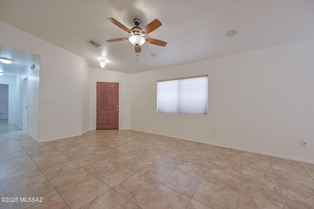 unfurnished room with a ceiling fan, visible vents, and baseboards
