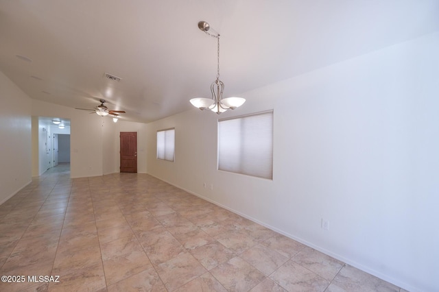 empty room with visible vents, ceiling fan with notable chandelier, and baseboards