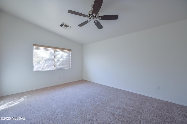 carpeted spare room with lofted ceiling, baseboards, visible vents, and ceiling fan