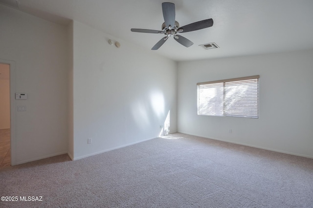 carpeted spare room featuring visible vents, baseboards, and a ceiling fan