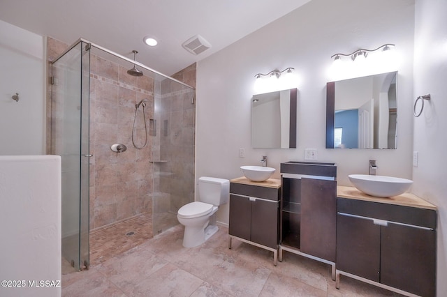full bathroom featuring visible vents, toilet, a stall shower, and vanity