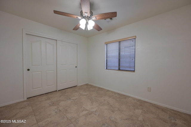 unfurnished bedroom with a closet, baseboards, visible vents, and ceiling fan