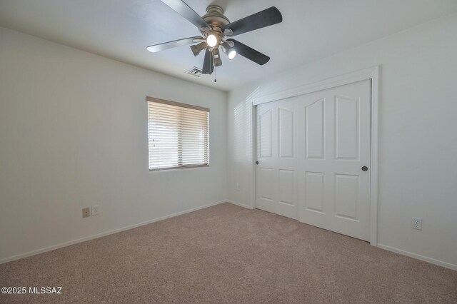 unfurnished bedroom featuring a closet, light colored carpet, and baseboards