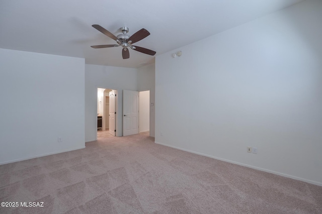 spare room featuring baseboards, lofted ceiling, light colored carpet, and a ceiling fan