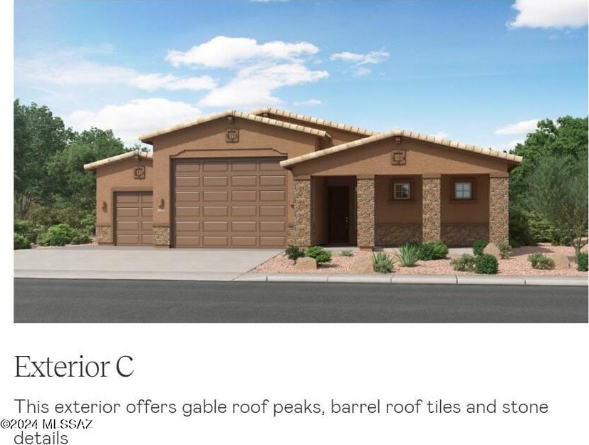 mediterranean / spanish home featuring a garage, stone siding, concrete driveway, and stucco siding