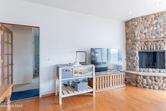 interior space featuring a stone fireplace and wood finished floors
