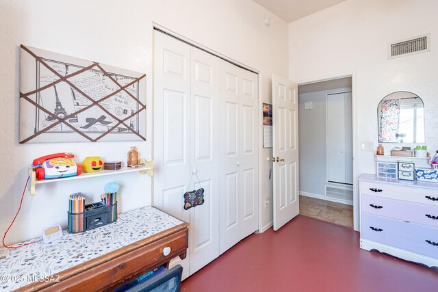 bedroom with visible vents, a closet, and concrete flooring