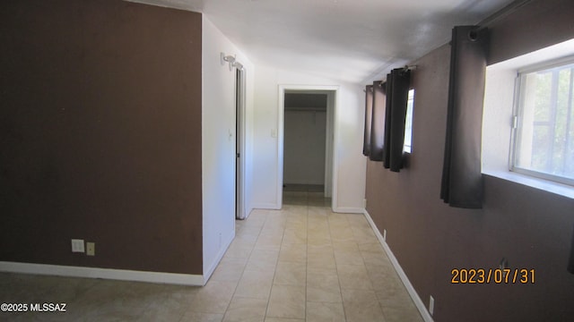 corridor with baseboards and vaulted ceiling