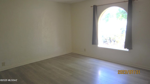 unfurnished room featuring baseboards and wood finished floors
