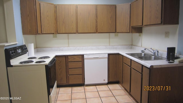kitchen with a sink, range with electric cooktop, light countertops, and white dishwasher