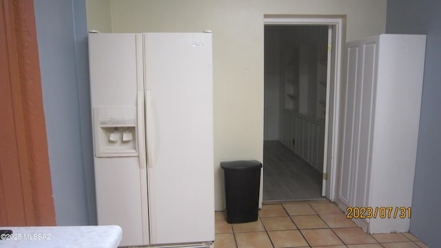 interior space with white refrigerator with ice dispenser and light tile patterned floors