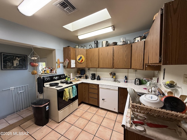 kitchen with visible vents, range with electric cooktop, light countertops, light tile patterned floors, and dishwasher