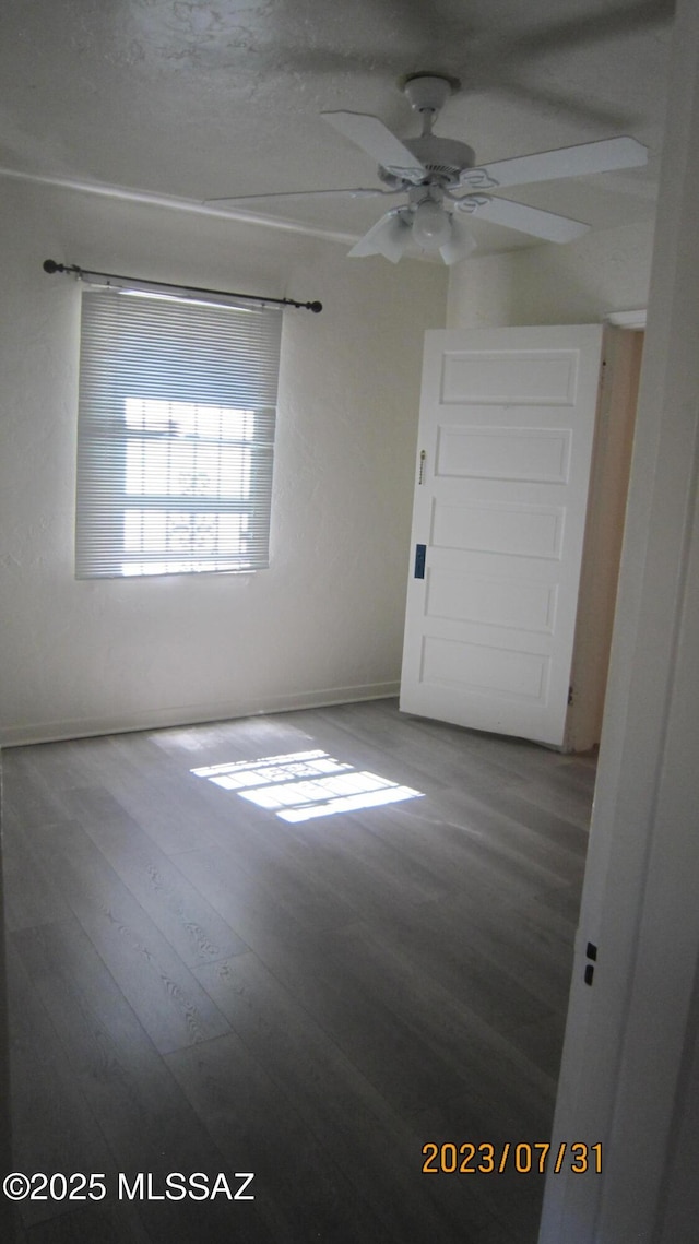 spare room featuring wood finished floors and ceiling fan
