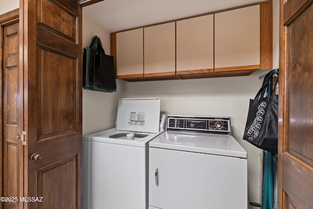 clothes washing area featuring washer and dryer and cabinet space