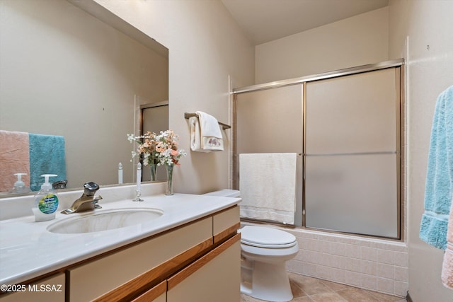 full bath with vanity, tile patterned floors, toilet, and shower / bath combination with glass door