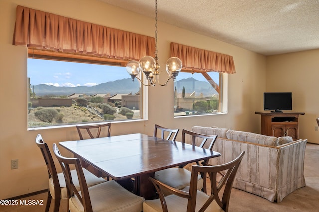 dining space with an inviting chandelier, light colored carpet, and a textured ceiling