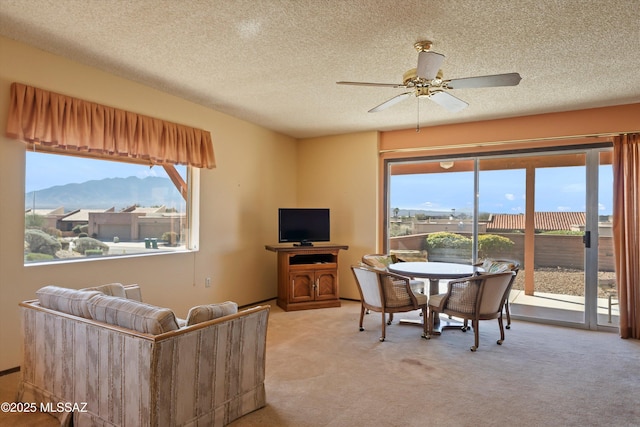 dining room featuring a ceiling fan, carpet, and a textured ceiling