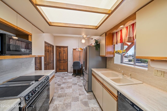kitchen featuring decorative backsplash, black appliances, light countertops, and a sink