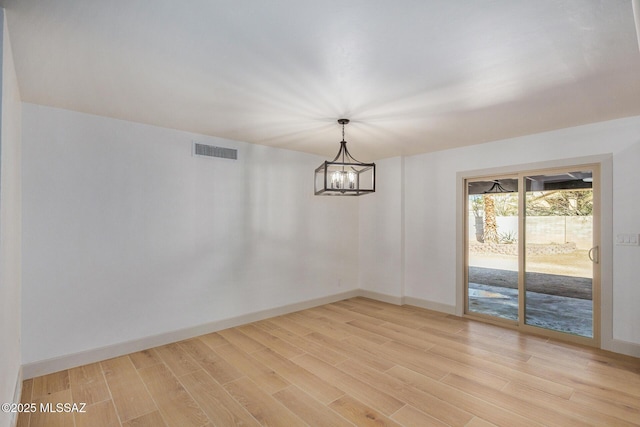 unfurnished dining area featuring a notable chandelier, light wood-style floors, visible vents, and baseboards