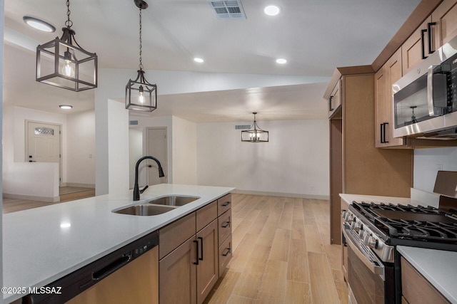 kitchen featuring light wood finished floors, visible vents, light countertops, stainless steel appliances, and a sink