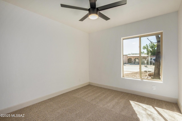 empty room featuring baseboards, light colored carpet, and a ceiling fan