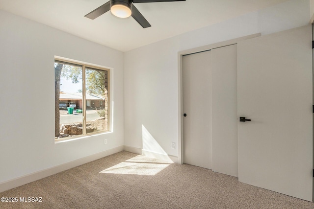 unfurnished bedroom featuring a closet, carpet flooring, and a ceiling fan