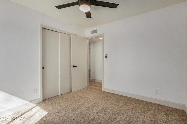 unfurnished bedroom featuring visible vents, a closet, ceiling fan, and carpet flooring